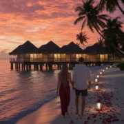 Couple walking hand in hand on a beach at sunset surrounded by rose petals and overwater villas — perfect romantic scene for a Maldives tour package