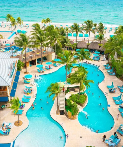 Vietnam tour package featuring luxury beachfront resort with tropical swimming pool, palm trees, and turquoise sea view.